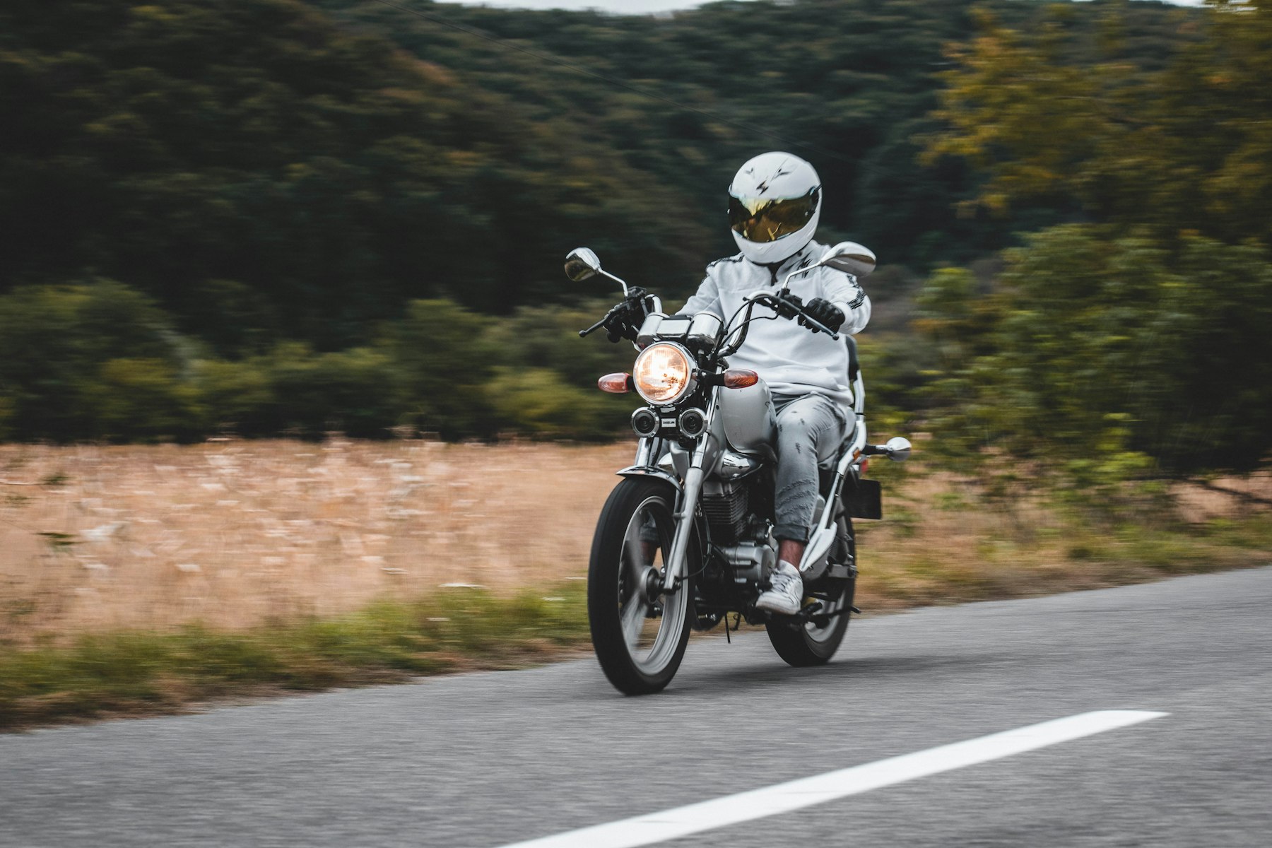 Motard penseur devant sa moto — réflexion sur les facteurs d’accident