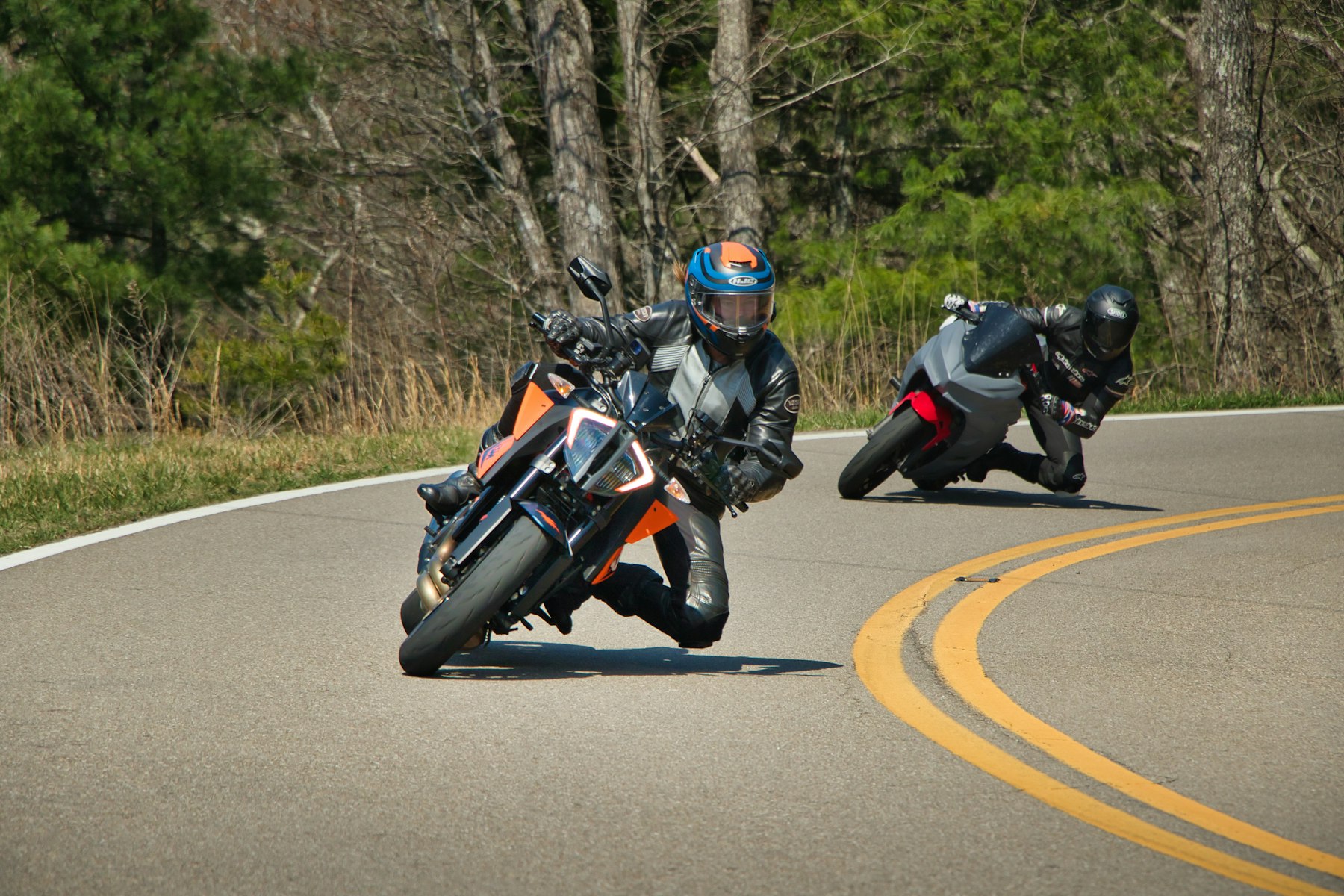 Deux motards en virage sur une route sinueuse — illustration de la circulation en groupe